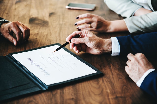 lawyers and clients hands on table discussing divorce paper