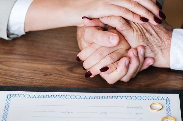 caucasian adults holding hands